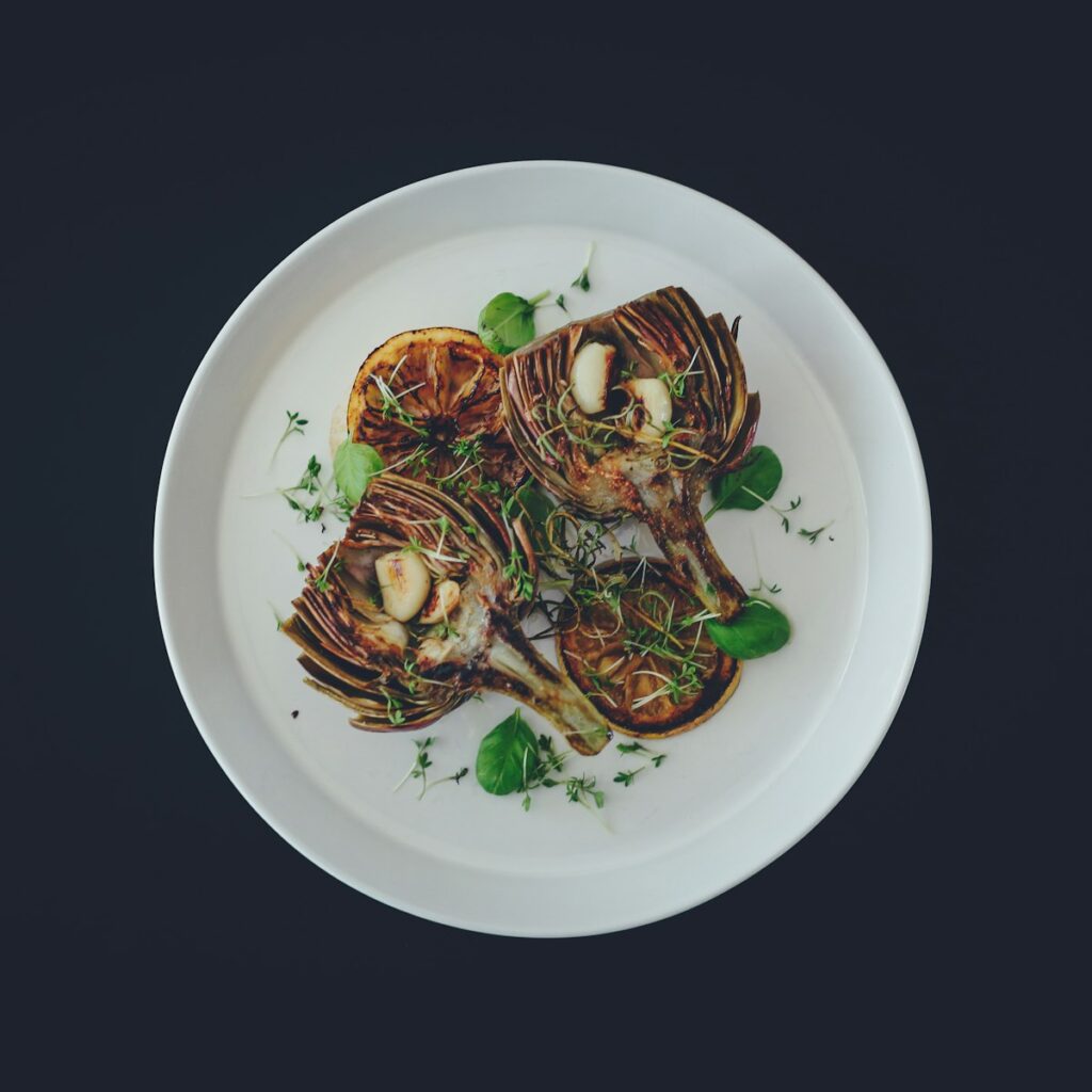 Charred artichoke on a white plate