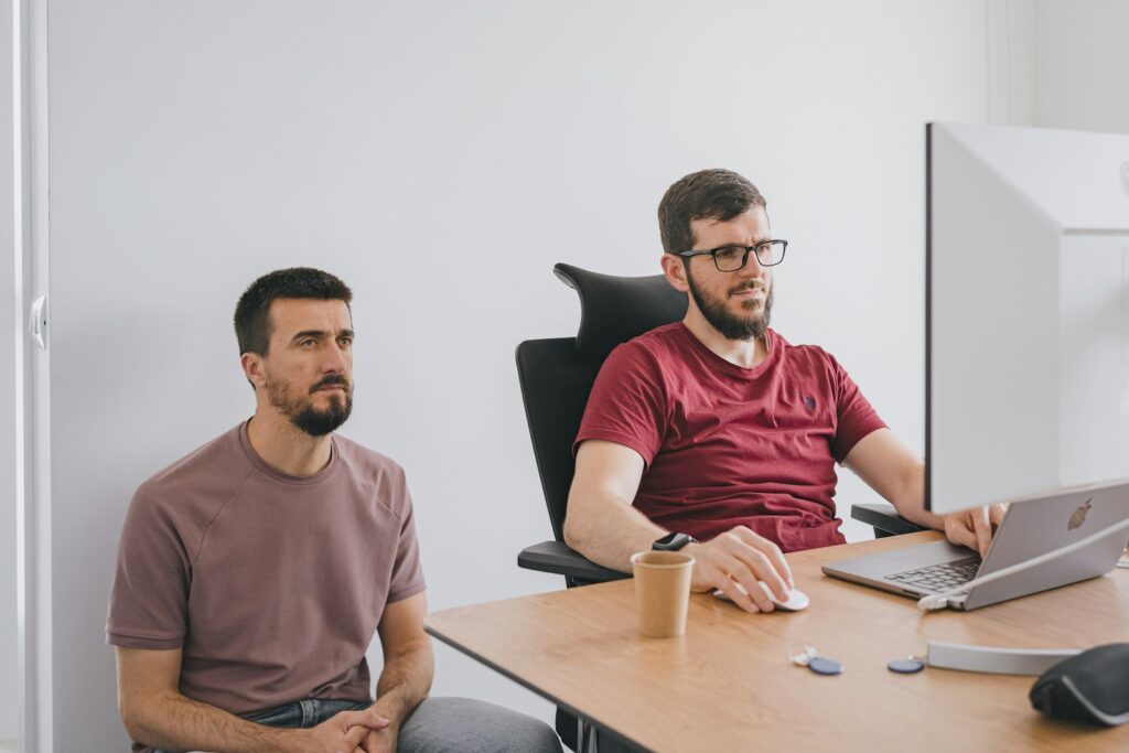 Two founders reviewing product metrics on a laptop in a bright office